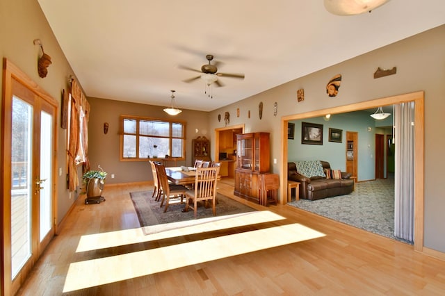 dining space with french doors, ceiling fan, and light hardwood / wood-style flooring