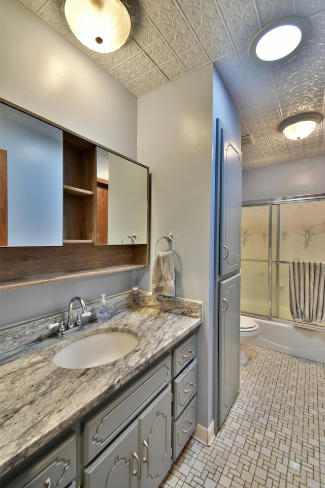 full bathroom with vanity, enclosed tub / shower combo, and toilet