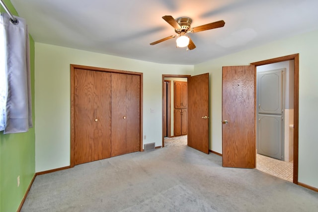 unfurnished bedroom featuring light carpet, ceiling fan, and a closet