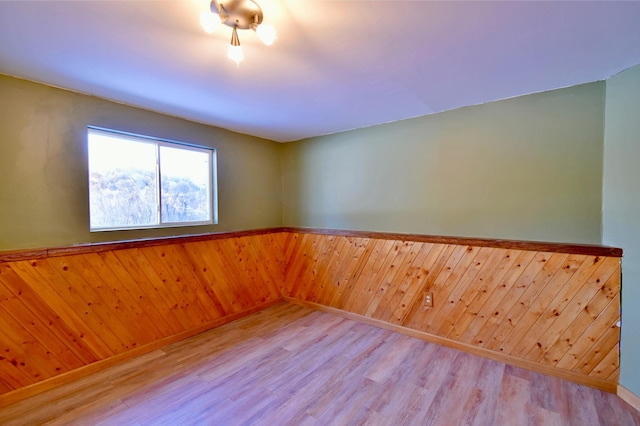 empty room featuring wood-type flooring and wood walls