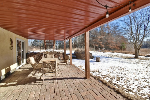 snow covered deck featuring a patio area