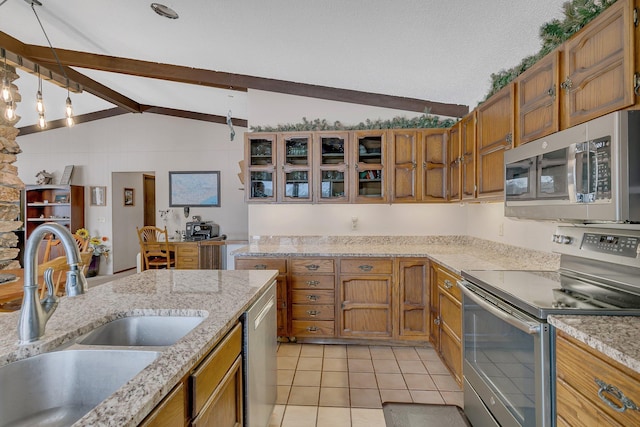 kitchen with light tile patterned flooring, sink, light stone counters, lofted ceiling with beams, and stainless steel appliances