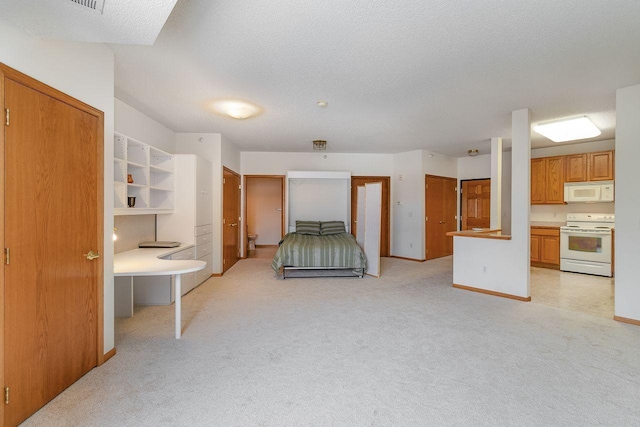 bedroom featuring ensuite bathroom, light colored carpet, and a textured ceiling