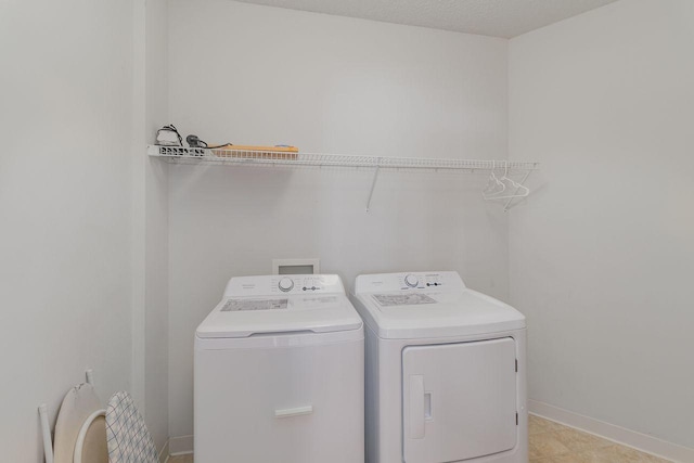 laundry room featuring washing machine and dryer and a textured ceiling