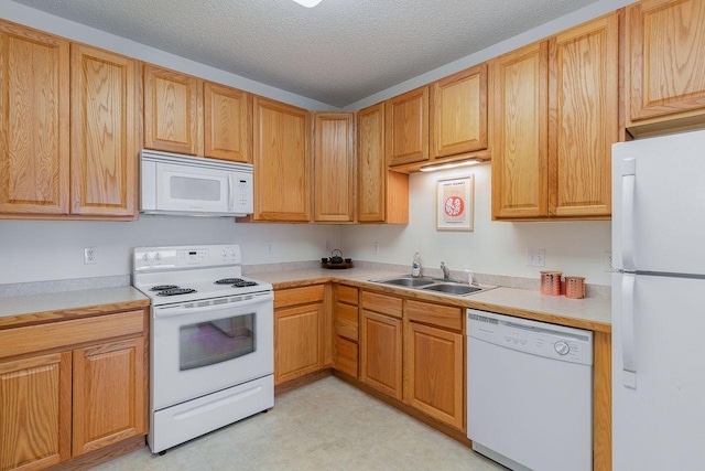 kitchen with sink, a textured ceiling, and white appliances