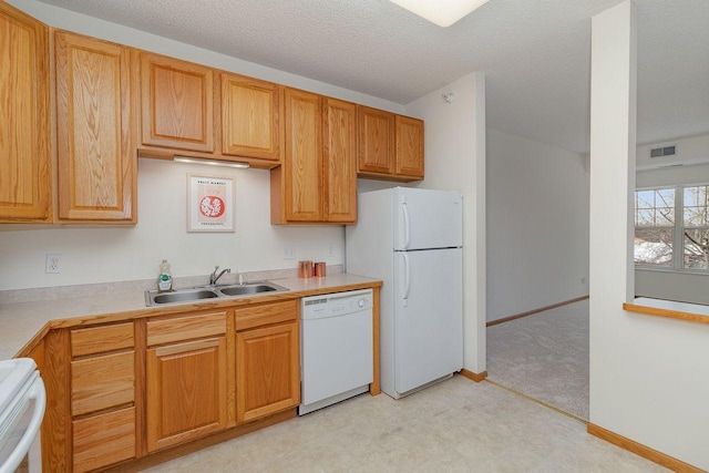 kitchen featuring sink, white appliances, and a textured ceiling