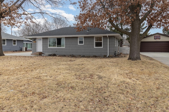 single story home with a garage, entry steps, an outbuilding, fence, and central air condition unit