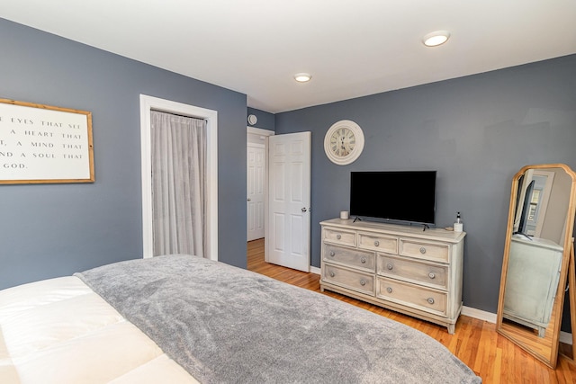 bedroom featuring a closet, baseboards, and wood finished floors