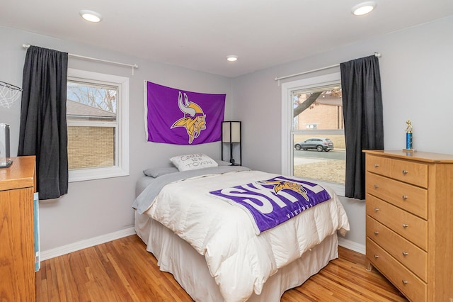 bedroom featuring light wood finished floors, multiple windows, baseboards, and recessed lighting