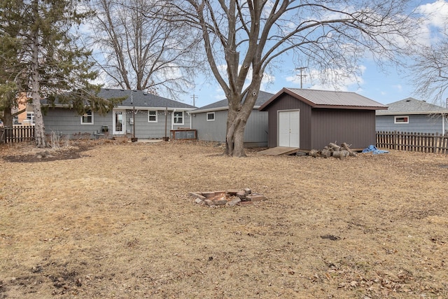 rear view of property featuring a fenced backyard, a storage unit, and an outdoor structure