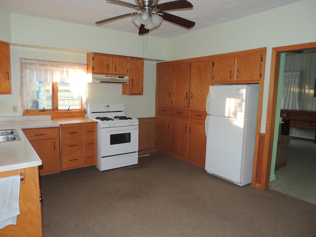 kitchen featuring ceiling fan, dark carpet, white appliances, and sink