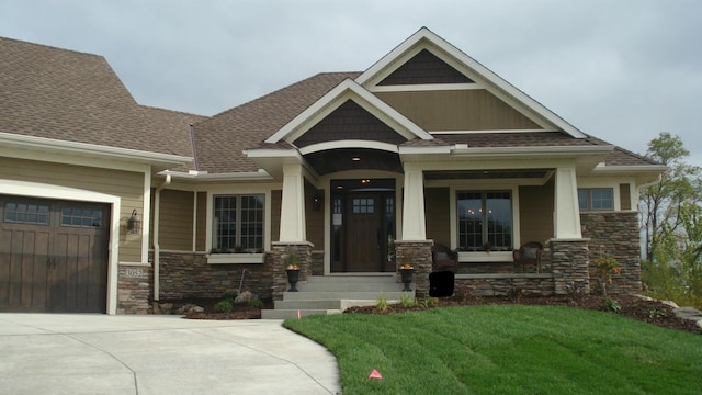 craftsman house with a garage and a front lawn