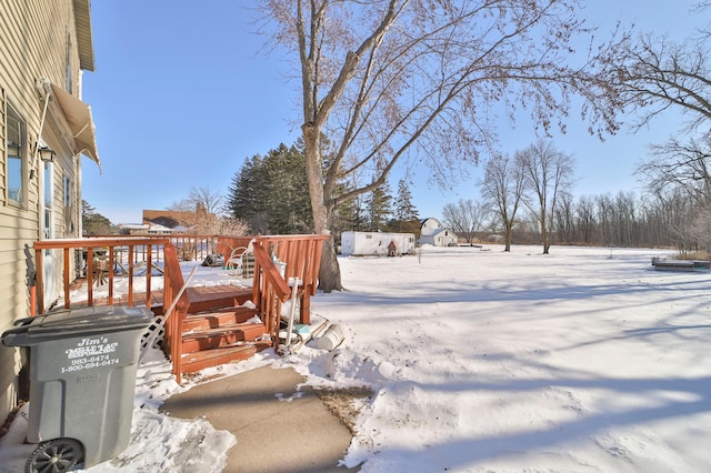 yard layered in snow featuring a wooden deck