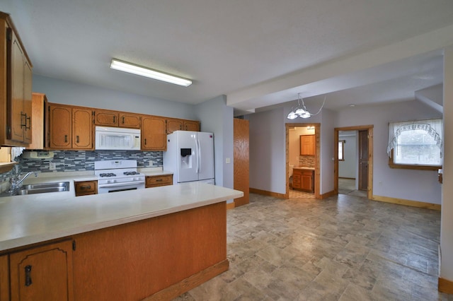 kitchen featuring backsplash, a peninsula, white appliances, a sink, and brown cabinetry