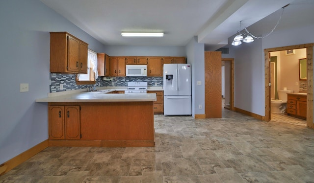 kitchen with light countertops, a peninsula, brown cabinetry, white appliances, and decorative backsplash