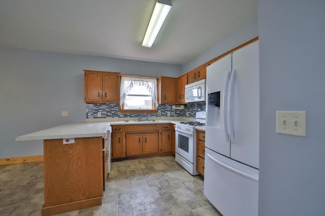 kitchen featuring light countertops, a sink, tasteful backsplash, a peninsula, and white appliances