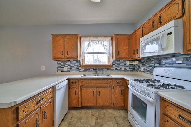 kitchen featuring backsplash, a sink, brown cabinetry, and white appliances