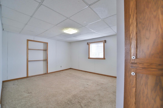 interior space with baseboards and a drop ceiling