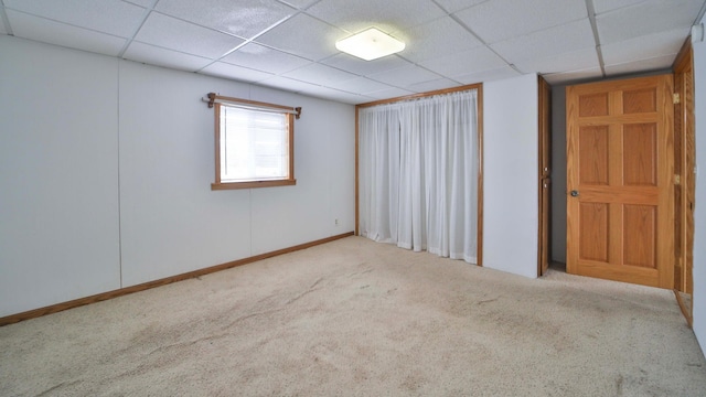 carpeted empty room with a drop ceiling