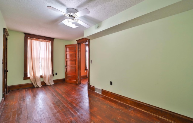 unfurnished room with a ceiling fan, a textured ceiling, wood-type flooring, baseboards, and visible vents