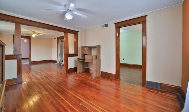 unfurnished living room with wood-type flooring, a ceiling fan, baseboards, and visible vents