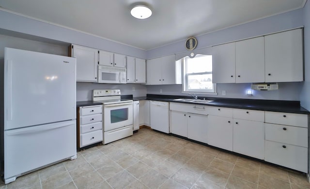 kitchen featuring white cabinets, a sink, dark countertops, and white appliances