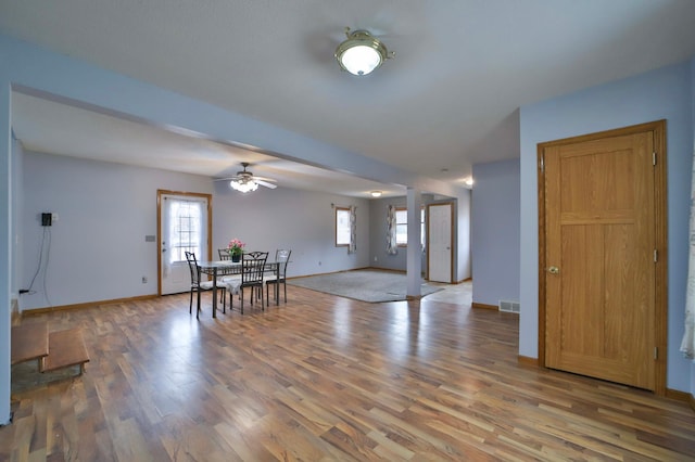 dining area with baseboards, visible vents, a ceiling fan, and wood finished floors