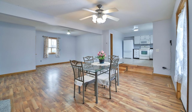 dining room with baseboards, light wood-style floors, and a ceiling fan