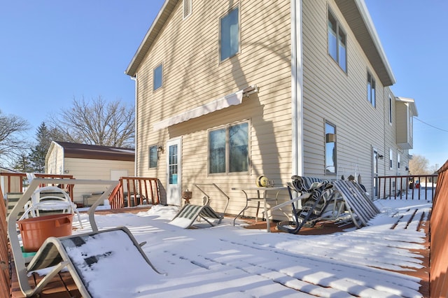 snow covered house with a wooden deck