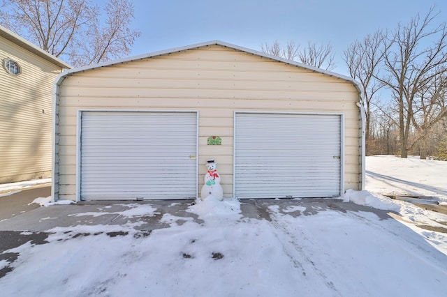 snow covered garage with a garage