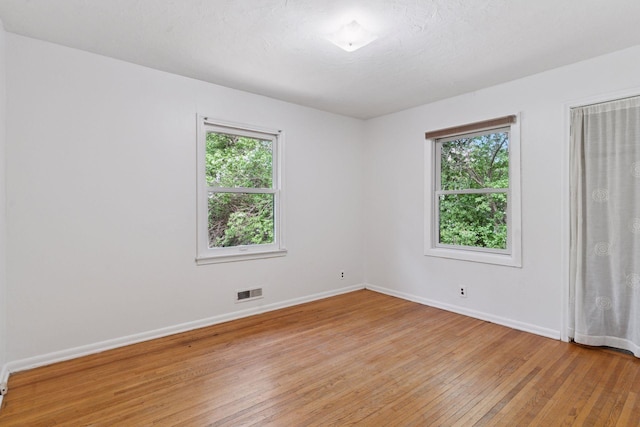 spare room with light wood-style flooring and baseboards