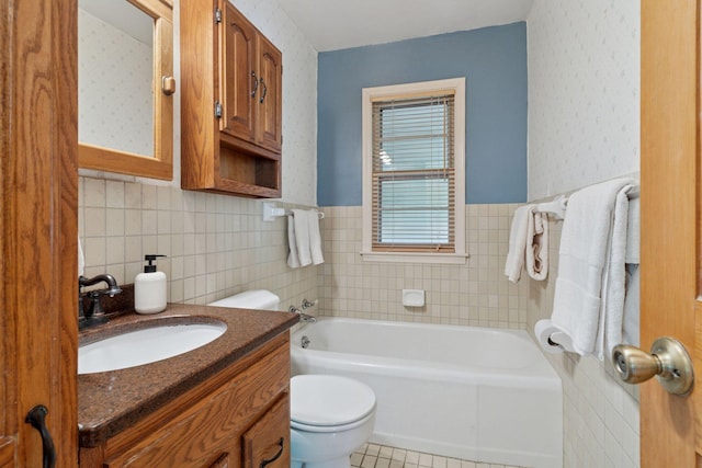 full bath with toilet, a tub to relax in, tile walls, vanity, and tile patterned flooring