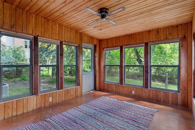 sunroom / solarium featuring wooden walls, healthy amount of natural light, and wooden ceiling