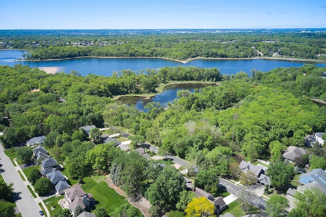 aerial overview of property's location featuring a forest and a nearby body of water