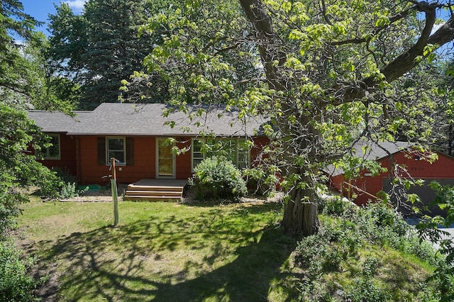 view of front facade featuring a front lawn and roof with shingles