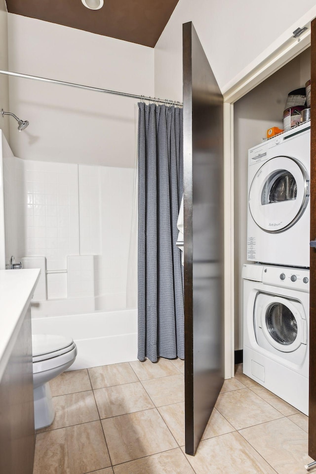 laundry area with light tile patterned flooring and stacked washer and clothes dryer