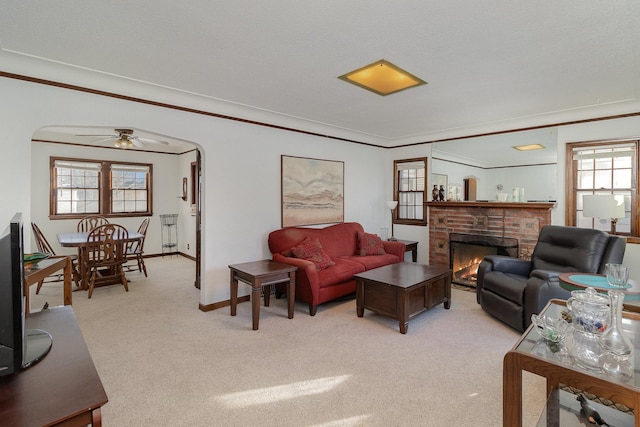 living room featuring light carpet, crown molding, and a fireplace