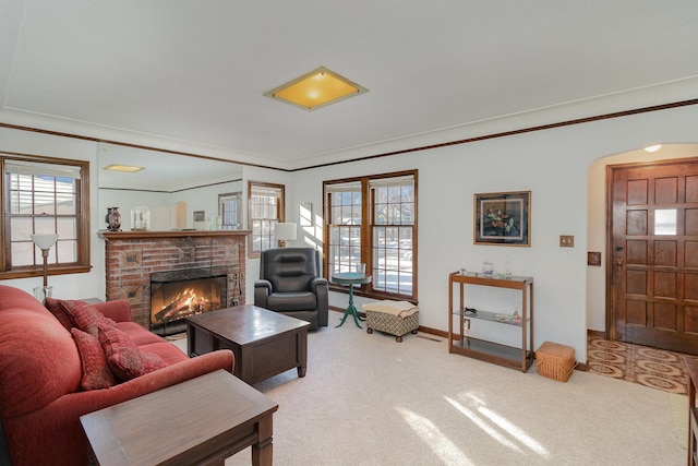 carpeted living room with a brick fireplace and ornamental molding