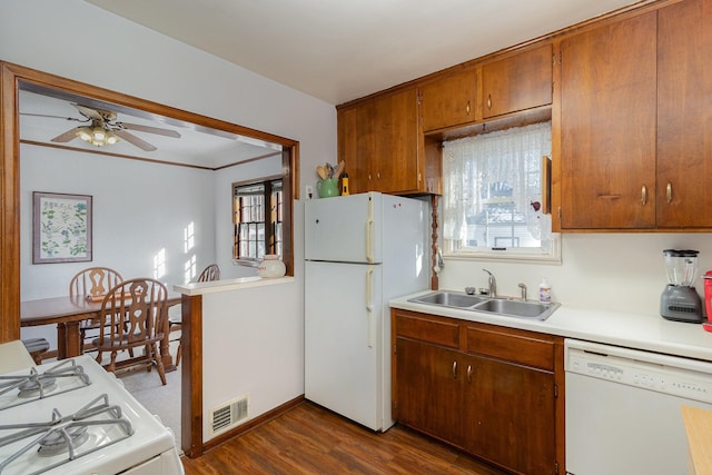 kitchen featuring white appliances, washer / dryer, dark wood-type flooring, sink, and ceiling fan