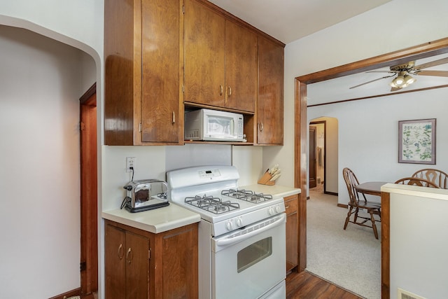 kitchen with ceiling fan, white appliances, and dark hardwood / wood-style floors