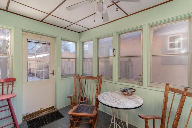 sunroom with a paneled ceiling and ceiling fan