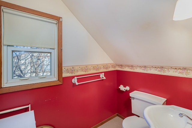 bathroom with sink, toilet, and vaulted ceiling