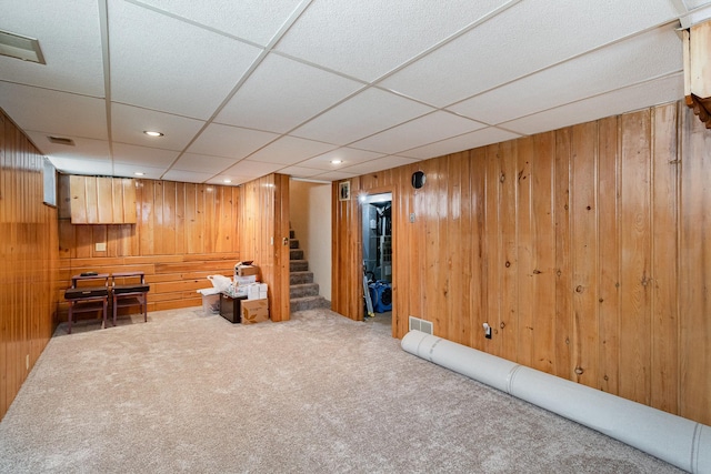 unfurnished room with wood walls and carpet flooring