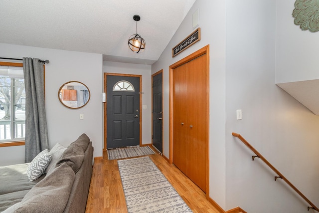 foyer entrance with lofted ceiling and light wood-type flooring