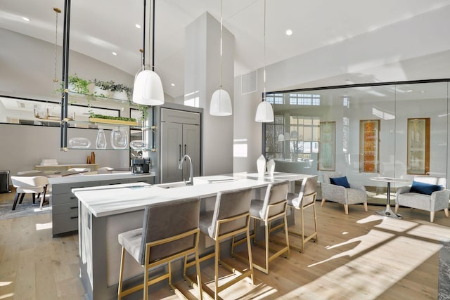 kitchen with pendant lighting, gray cabinetry, a spacious island, and lofted ceiling