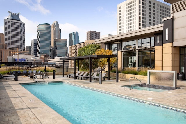 view of swimming pool featuring a hot tub and a patio