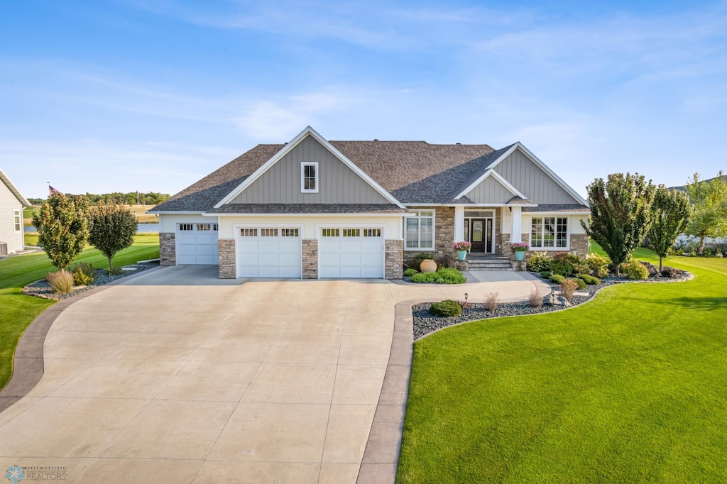 craftsman inspired home with a garage and a front lawn