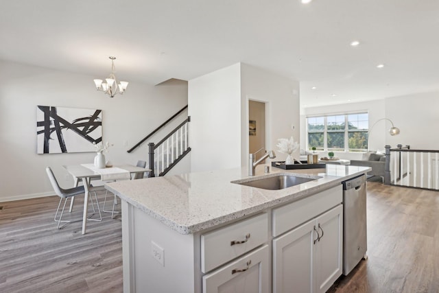 kitchen with pendant lighting, white cabinetry, a kitchen island with sink, a chandelier, and stainless steel dishwasher