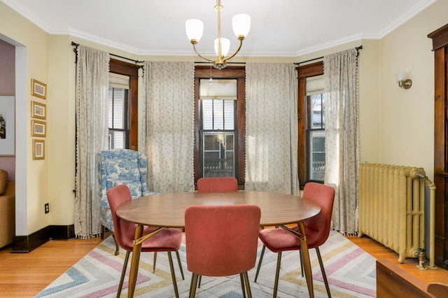 dining space featuring crown molding, radiator, and light hardwood / wood-style flooring