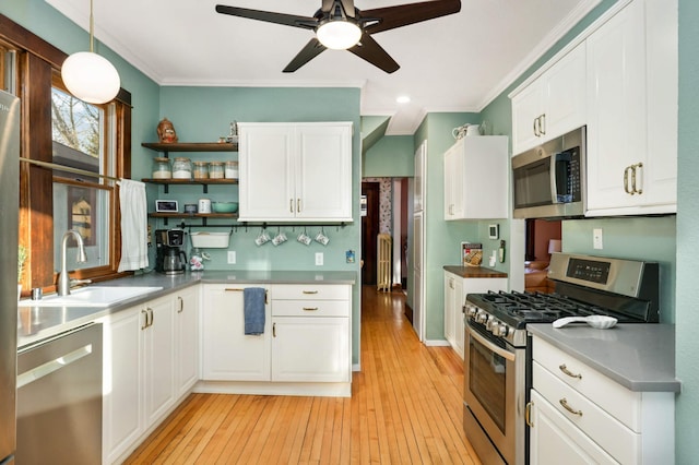 kitchen with stainless steel appliances, sink, pendant lighting, and white cabinets